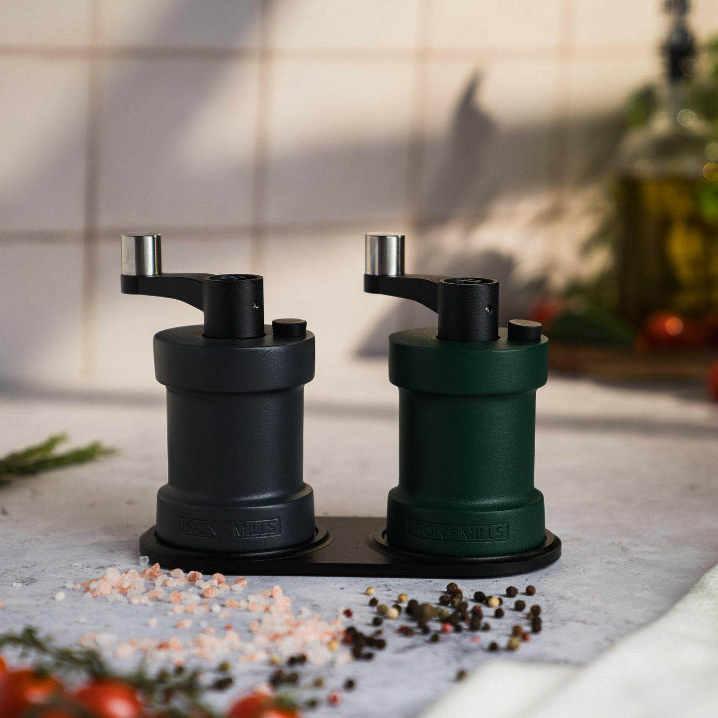 Iron-Mills anthracite grey and ivy green salt and pepper mills displayed on a handcrafted wooden mill base